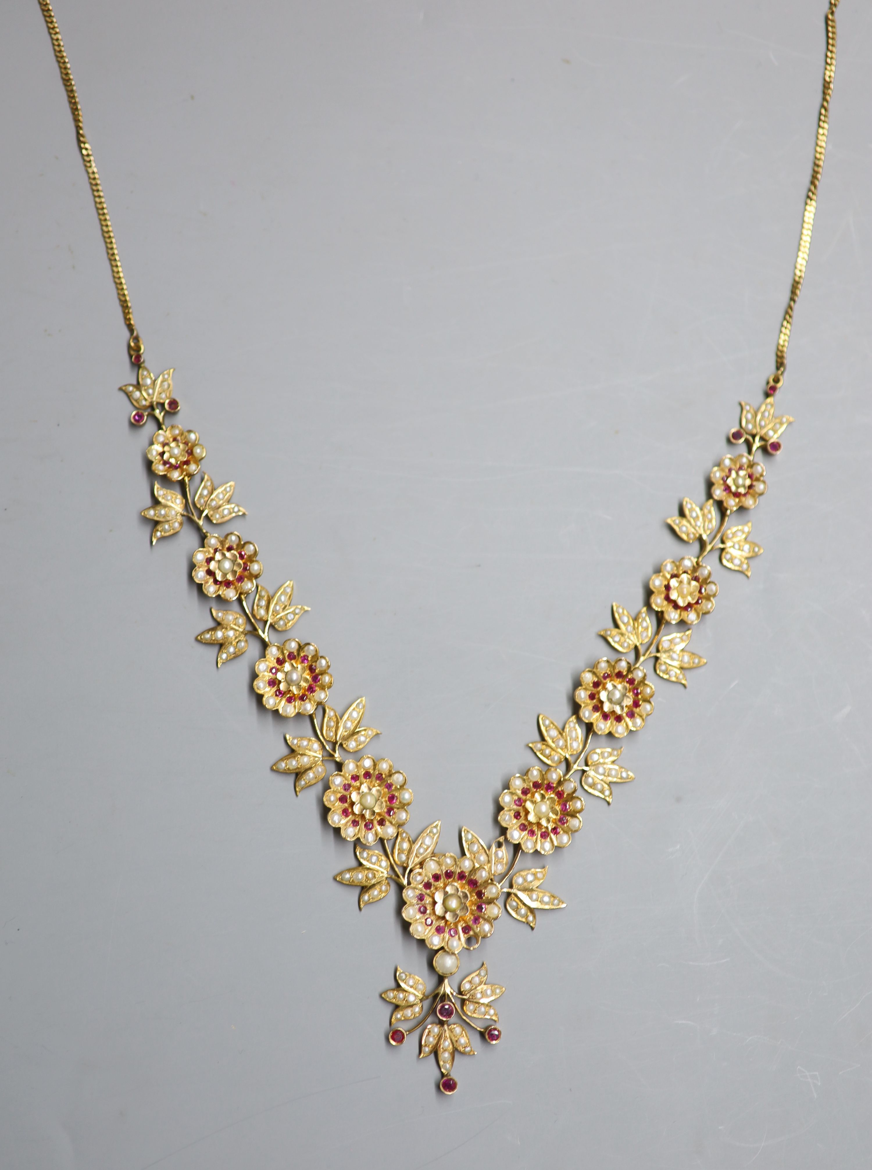 An early to mid 20th century Indian gilt metal, ruby and split pearl floral cluster drop necklace, approx. 50cm.